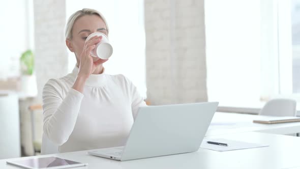 Smart Young Businesswoman Having Coffee in Modern Office