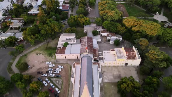 Aerial dolly out shot revealing a neogothic church in a small town at sunset