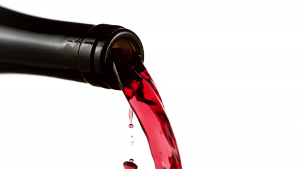 Super Slow Motion Detail Shot of Pouring Red Wine From Bottle Isolated on White at 1000Fps.