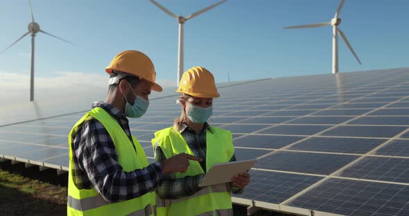 Working people with digital tablet  wearing safety masks - Alternative renewable energy