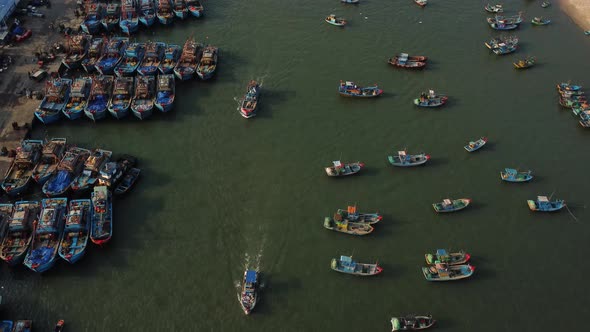 Countless motley boats are moored near the pier, while 2 boats are sailing one after another on the