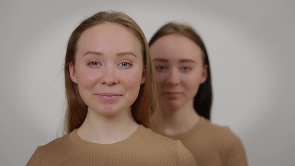 Closeup Face Charming Cheerful Young Woman Looking at Camera Smiling with Blurred Twin Sister