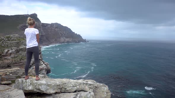 Wideshot of a Young Blonde Woman Looking at Cape of Good Hope near Capetown