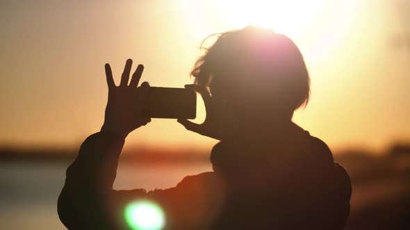 Silhouette of a Man Who Shoots a Landscape on the Phone