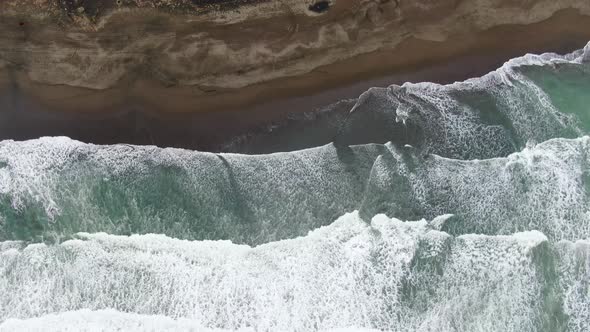 Aerial top-down forward over big waves breaking on Suwuk beach at Kebumen, Indonesia