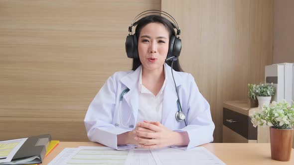 Young attractive Asian female doctor diagnosis talking and looking to camera