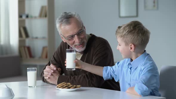 Small Grandson Clinking Glasses of Milk With His Grandfather, Nutritious Lunch