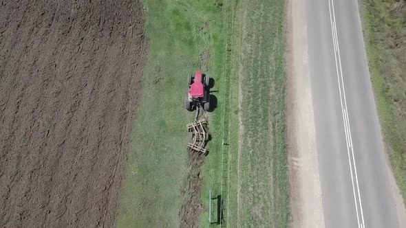 Tractor with angled Disc Harrow breaks up hard African ground