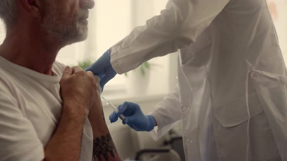 Mature Patient Getting Vaccine Dose in Clinic Closeup