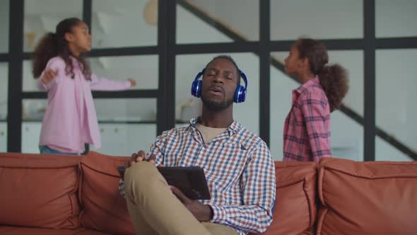 Dad in Headphones Ignoring Scolding Kids at Home