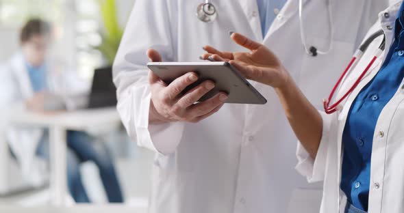 Cropped Shot of Medical Team Discussing Over Digital Tablet at Hospital