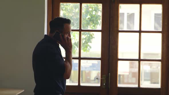 Businessman talking on mobile phone in office 4k