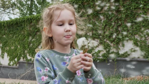 a Teenage Preschooler Girl Holds a Bouquet of Shoes in Her Hand and Blows Air on Them Inflating