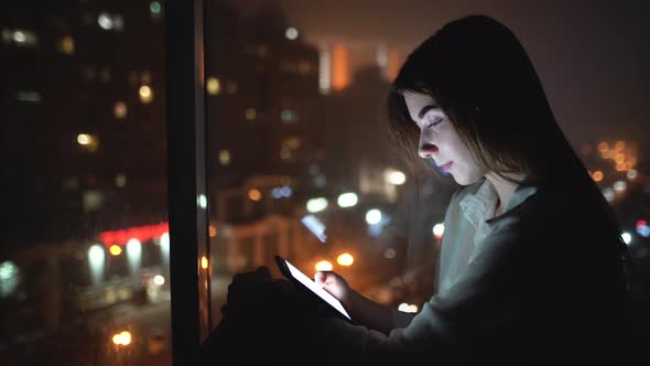 Young Caucasian Lady is Sitting Near the Window