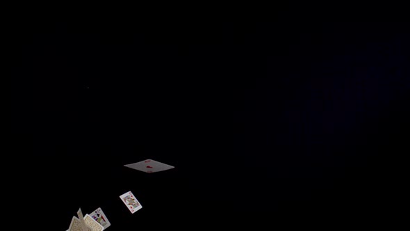 Playing cards falling on black background, Slow Motion