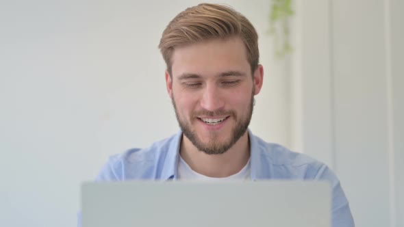 Portrait of Successful Creative Man Celebrating on Laptop at Work