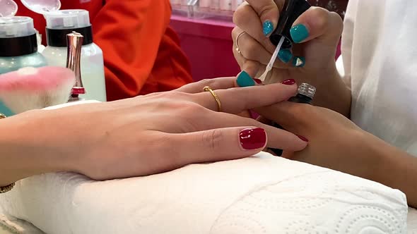 Closeup of Woman Hands at Beauty Salon Receiving a Manicure and Nail Care Process By Manicurist