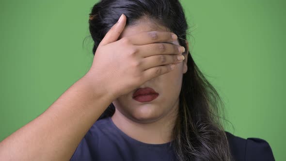 Young Overweight Beautiful Indian Businesswoman Against Green Background