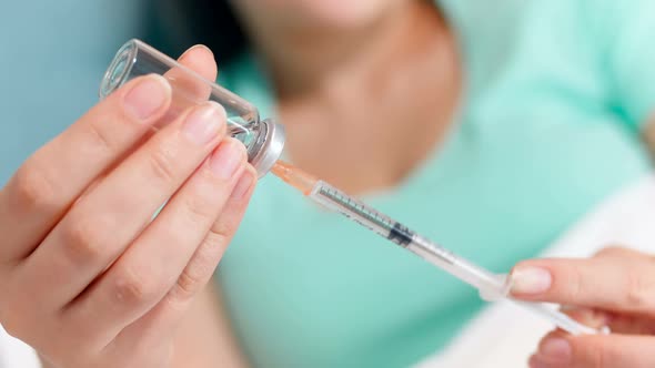 Closeup  Footage of Young Woman Filling Syringe with Medicines From Ampule