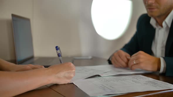 Businesspeople Inside of Private Jet Plane Signing Agreement Contract