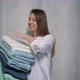 A Young Housewife Woman Holds a Stack of Fresh Washed Clean Linen in Her Hands - VideoHive Item for Sale