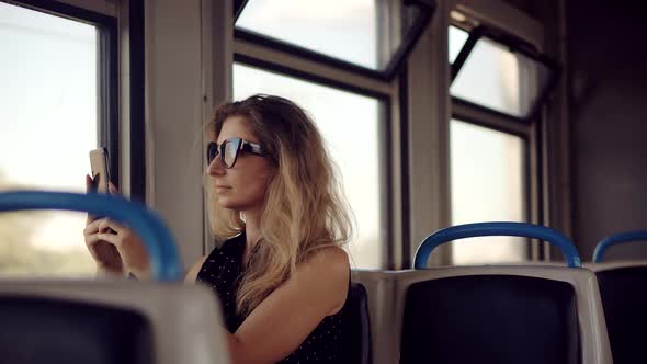 Female Traveler On Train Using Smartphone App For Photo. Woman Tourist Looking On City.