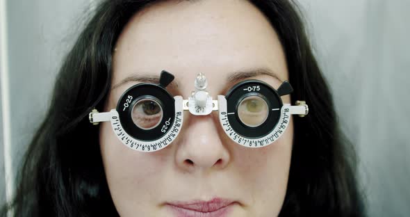 Close Up Eyesight Measurement To Young Woman with Optical Phoropter. Woman Doing Eye Test Slow