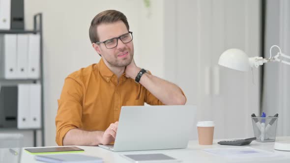 Young Man Having Neck Pain in Office