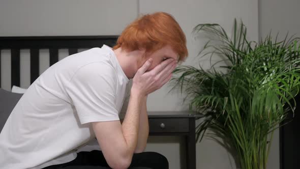 Upset Sad Redhead Man Sitting on Side of Bed