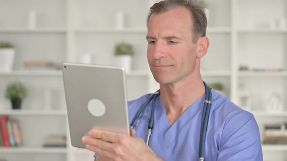 Portrait of Serious Middle Aged Doctor Using Tablet