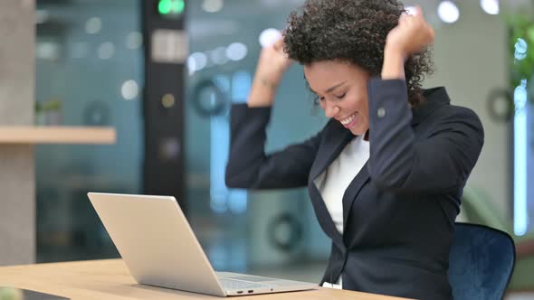 African Businesswoman Excited for Success on Laptop at Work