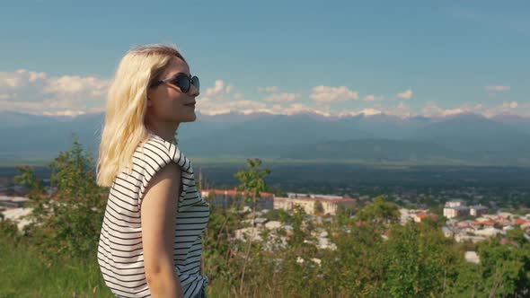 Profile Shot of a Blonde Caucasian Girl Enjoying a Beautiful View of Mountains and Looking to the