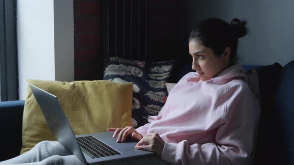 Young Indian Woman Sitting On The Sofa At Home And Working On The Computer