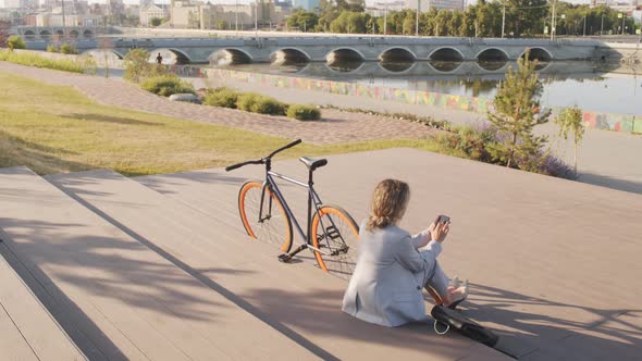 Businesswoman with Bike Sitting at Waterfront