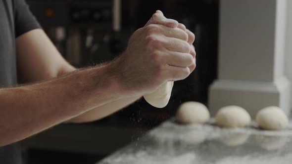 Crop man shaping dough balls