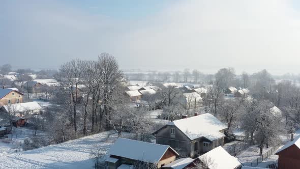 Winter aerial landscape in village. Houses covered with white snow