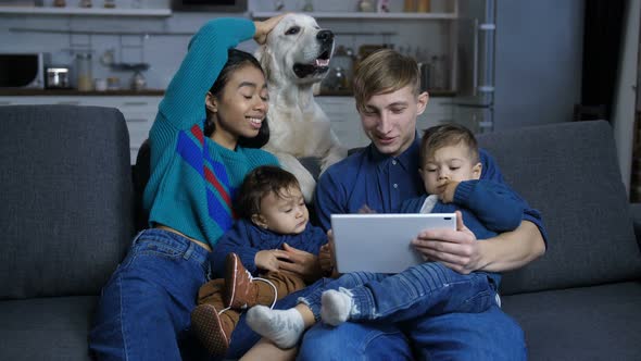 Woman Petting Dog While Family Relaxing on Sofa