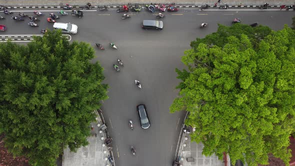 The traffic of vehicles at a crossroads in the city of yogyakarta. Top aerial drone view.