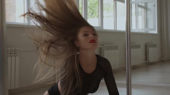 Flexible Woman Dancing on Pole in Studio