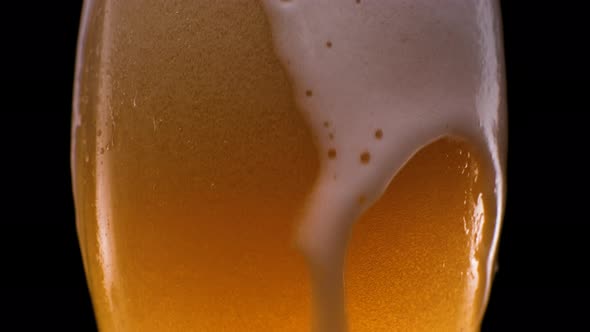Light Beer Pouring in Glass with Foam