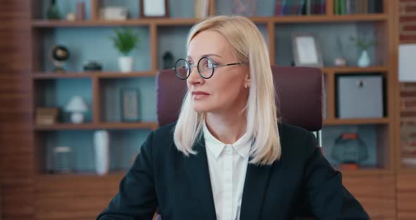 Businesswoman in Glasses Looking Away and Then Turning Her Head Into Camera