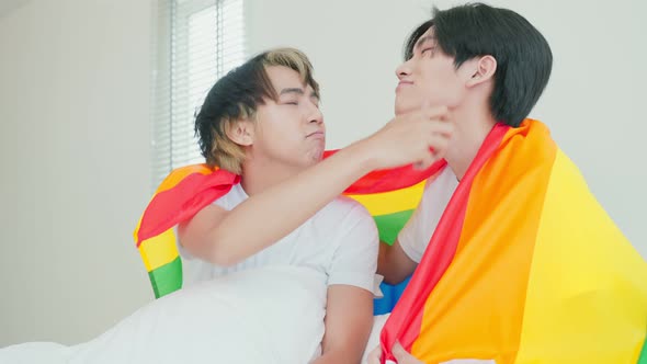 Portrait of Asian handsome man gay family holding LGBT flag and smile.