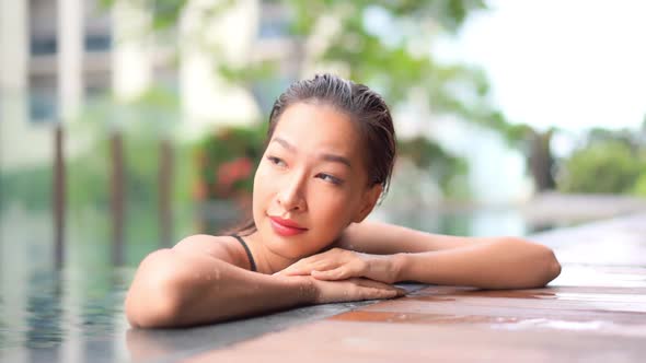 Young asian woman enjoy around outdoor swimming pool for leisure