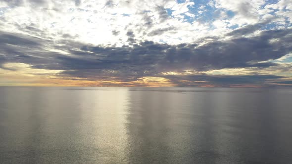 AERIAL: Flying Backwards Above Baltic Sea During Golden Hour with Majestic Horizon