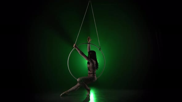 Aerial Acrobat in the Ring. A Young Girl Performs the Acrobatic Elements in the Air Ring on Green