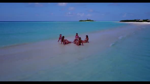 Girls tanning on luxury island beach vacation by blue sea with white sand background of the Maldives