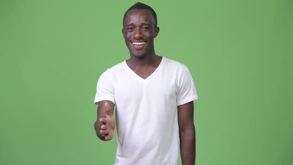 Young African Man Smiling While Giving Handshake