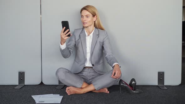 Businesswoman Making a Video Call Sitting on the Floor Online Meeting with Team