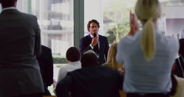 Business people applauding male speaker in a business seminar 4k