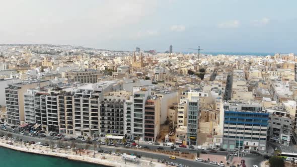 Aerial Pull Up Shot Revealing The Town of Sliema From The Coastline